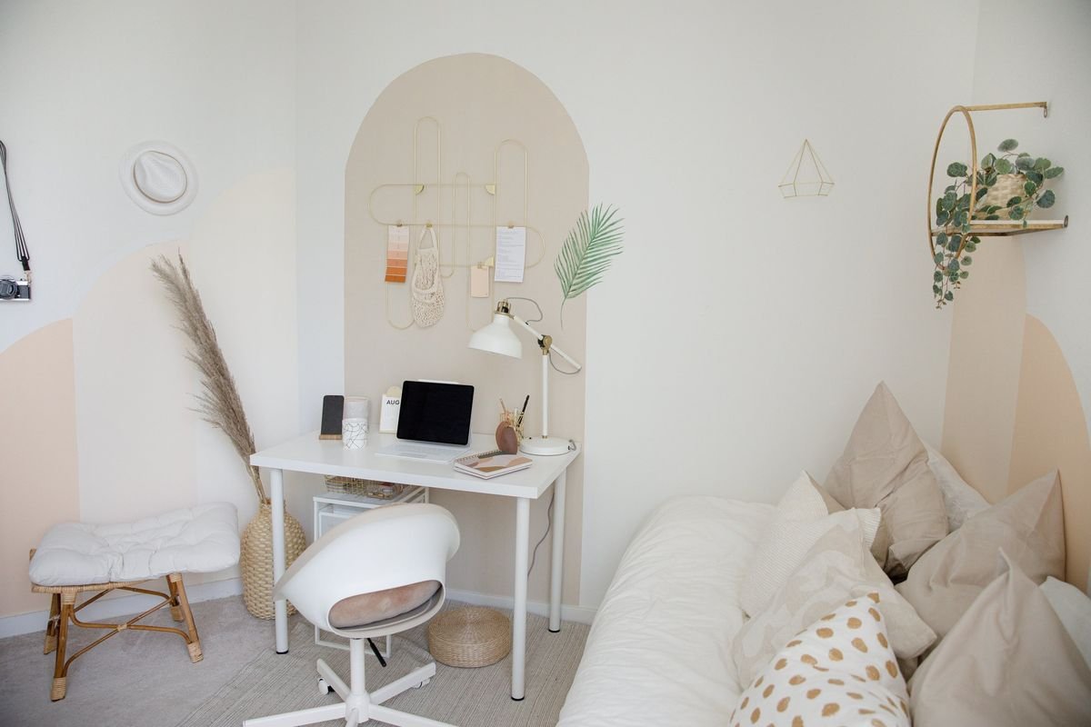 A bright, calm home workspace with a small desk, a lamp and soft cushions